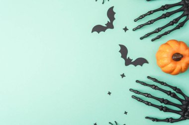 İskelet elli Cadılar Bayramı teması, yarasalar, yıldızlar ve açık yeşil arka planda balkabağı.