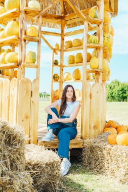 Kabakların ve kabakların arasında dinlenen kırsal ahşap yapıda bir kadın.