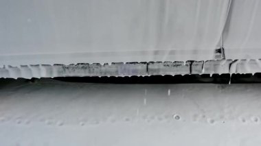 Beyaz temizlik köpüğü, otomatik yıkama sahasında koyu renk bir araç yüzeyine damlıyor. Kalın köpükler otomotiv gövdesini kaplar.