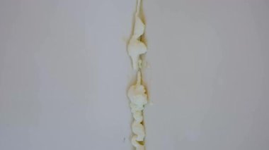 Genişletilmiş köpük dolgu macunu desenli beyaz bir duvardaki dikey boşluğu doldurur. Ev yapımı ve yalıtım işleri için onarım malzemesi. Dikey bir duvar dikişine uygulanan genişleyen beyaz köpük izolasyonunu kapat. 