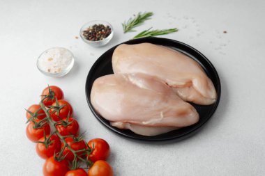 Çiğ tavuk göğsü ve taze domates, tuz, biber ve biberiye.