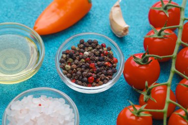 Mavi arka planda siyah biber, tuz, domates ve biber yakın çekim