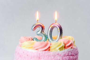 Renkli bir doğum günü pastası mumlarla süslenmiş bir dönüm noktası kutlaması..