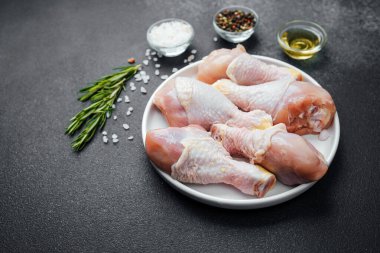 Tavuk budu çiğ, baharatlı ve otlu beyaz tabakta.