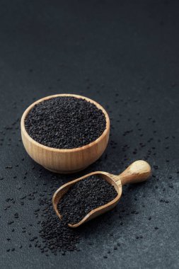 Kasede siyah susam tohumları ve koyu arka planda kepçe