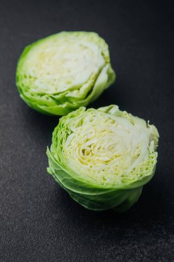 Karanlık arka planda iki kesik lahana parçası. Yakın plan.