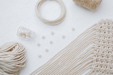 Beyaz arka planda jüt halat, inci ve ahşap halkalar ile Macrame malzemeleri