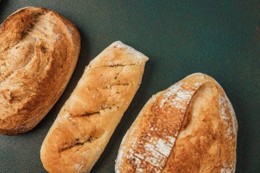 Tahta bir yüzeyde üç farklı tür zanaatkar ekmek sergilenir..