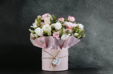 Şık bir kutuya yerleştirilmiş canlı bir buket gül ve yeşillik hediye etmek için mükemmel..