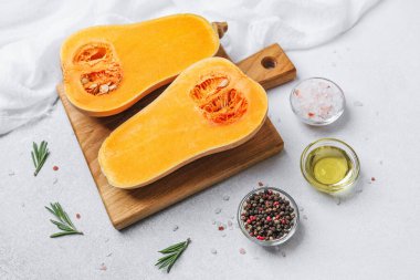 İçinde biberiye, tuz, yağ ve biber bulunan yarım tereyağlı kabak.