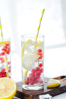  Limon kırmızısı frenk üzümü suyu ve güneş ışığında sarı şeritli kamışlı uzun bardak.