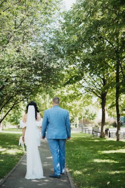 Gelin ve damat düğün ve aşk konsepti için el ele yürüyorlar.