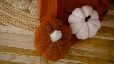 İki peluş balkabağı, bir portakal, bir beyaz, kırsal ahşap zeminde.