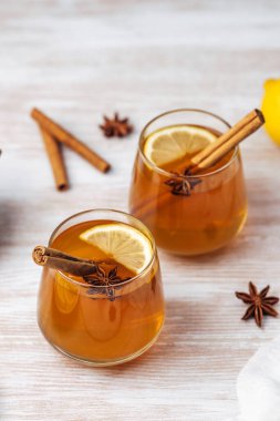 Tarçınlı elma şarabı, limon dilimleri ve ahşap bir masada yıldız anason.