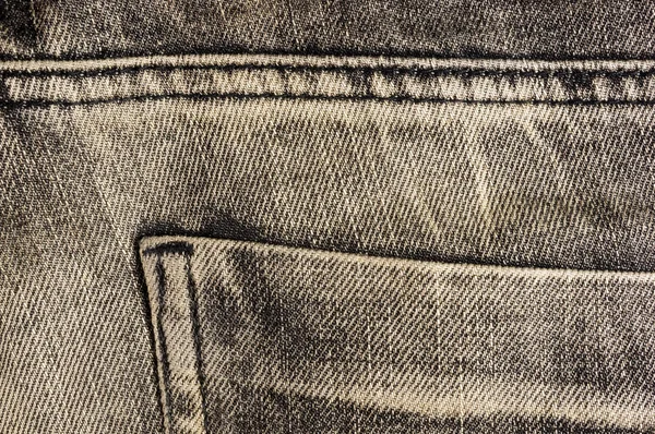 Black washed faded jeans texture with seams, clothing items, macro, close-up