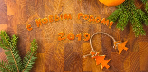 New Year Concept. Christmas decorations hand made from tangerine peel and fir-tree branches, printed layout of the postcard, russian text