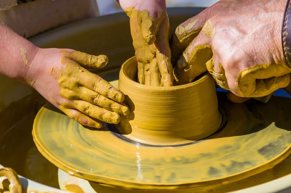 hands of the skilled master Potter and children\'s hands, training of the kid to production of pottery on a Potter\'s wheel