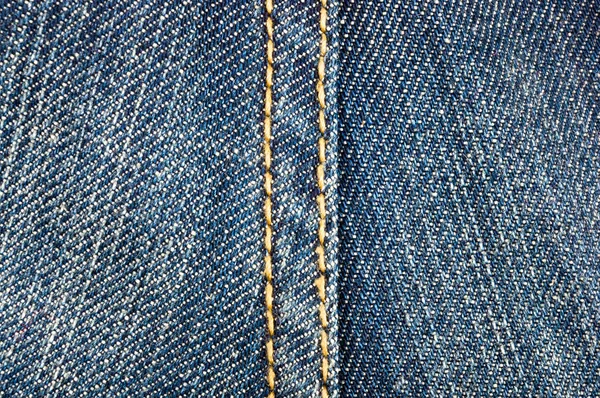 clothing items blue stonewashed faded jeans cotton fabric texture with seams, clasps, buttons and rivets, macro, close-up