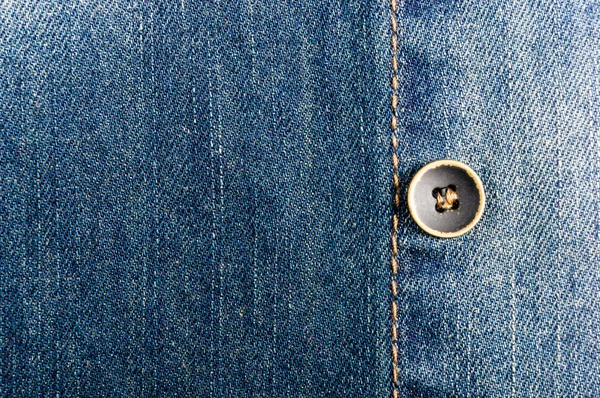 clothing items blue stonewashed faded jeans cotton fabric texture with seams, clasps, buttons and rivets, macro, close-up