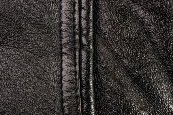 Old vintage genuine soft black leather texture background, top layer with pores and scratches, macro, close-up