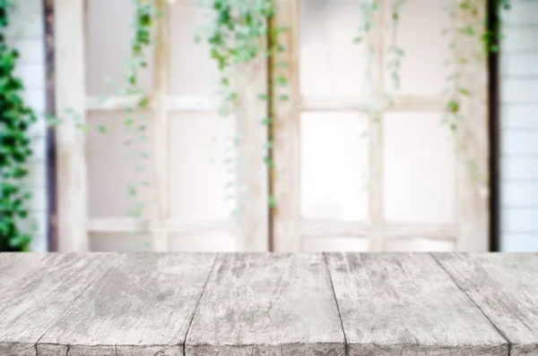 empty wooden desk over blurred interior decoration background.