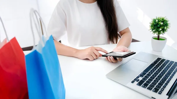 online ödeme alışveriş için mobil akıllı telefon kullanan mutlu genç kadın.