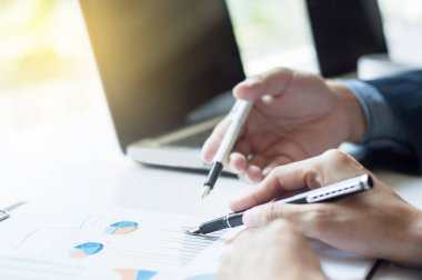 Şirket yöneticileri veri ile dizüstü bilgisayar arka plan üzerinde tartışıyor