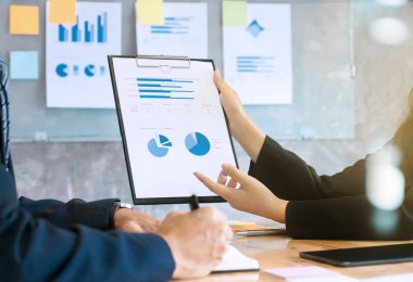 iki şirket yöneticileri toplantı salonu, bir pano kağıda veri analiz