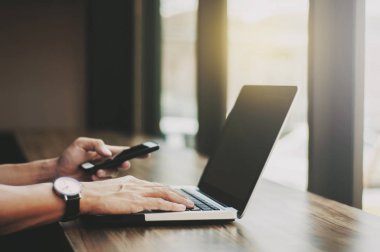 dizüstü bilgisayarda çalışma ve mobil akıllı telefon işyerinde kullanarak iş adamı