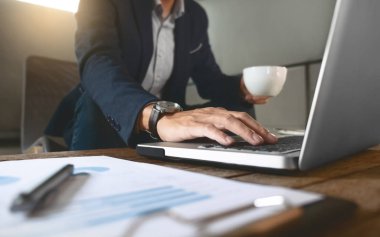 işletme belgesi ve dizüstü bilgisayar üzerinde bir işyerinde çalışan iş adamı