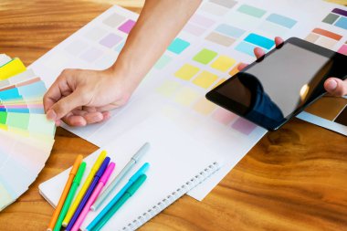 Tablet kullanma ve modern bir ofis masasında grafiklerde renk üzerinde yaratıcı iş kadını
