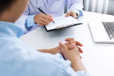 hasta ve doktor hastane veya klinik notlar alarak yakın çekim