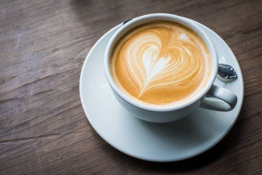 Yüzeyde latte süt sanat ile sıcak latte kahve bir fincan.