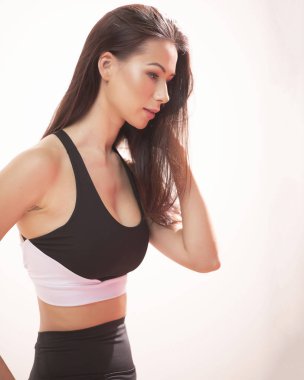 Güzel uzun saçlı güzel pilates portresi veya bir stüdyoda beyaz bir arka plan karşı sıkı spor kıyafeti giymiş süre zarif bir poz bir taburede oturup yoga atlet