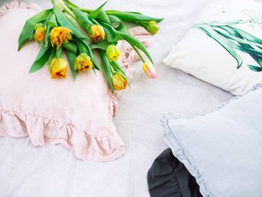 Lale yastıklar yatakta yatan bir buket