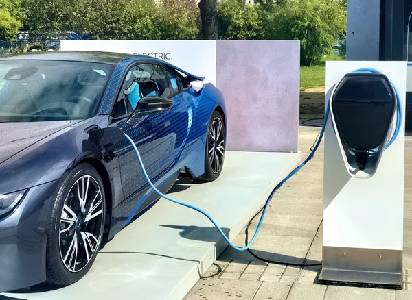 Electric vehicle being plugged in — Stock Photo, Image