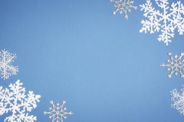 Mavi zemin üzerine desen beyaz kar tanesi. Noel dekor kopya alanı ile
