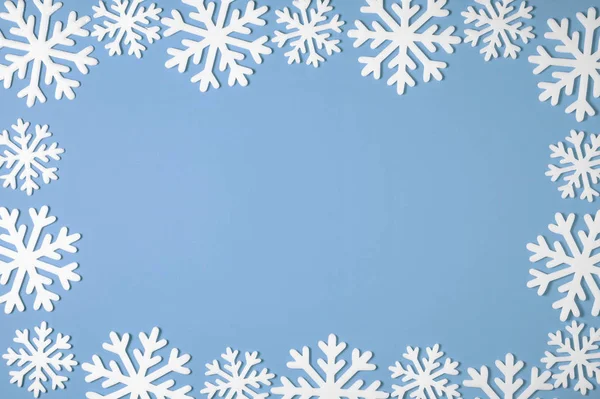Marco de borde de copo de nieve de Navidad sobre fondo azul. Textura mínima de Navidad con espacio de copia. vista superior —  Fotos de Stock