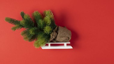 Oyuncak bir kızak üzerinde kağıt kırmızı arka plan ile Noel ağacı