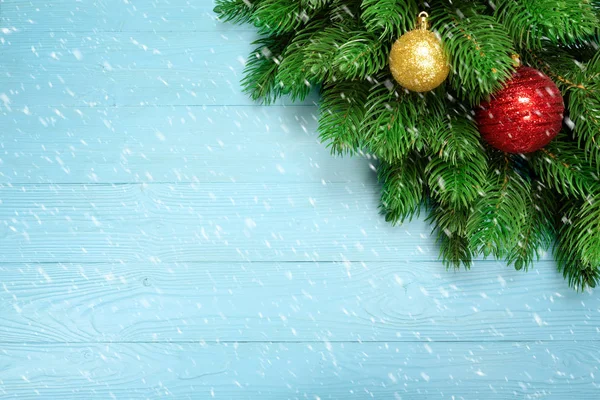 Sfondo di Natale con rami di abete e neve, fiocco di neve, nuove decorazioni anno palla giocattolo o palline su sfondo di legno blu — Foto Stock