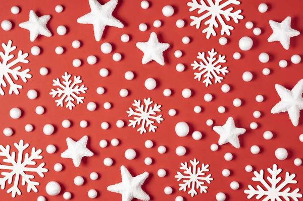 Modèle de Noël composé de flocons de neige blancs, de neige et d'étoiles sur fond rouge. Concept d'hiver. Pose plate — Photo