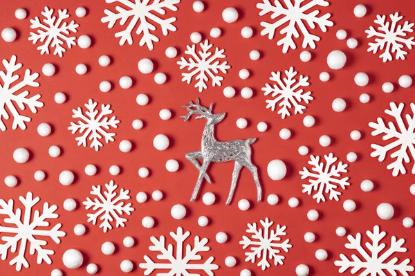 圣诞节的成分由白色雪花, 红色背景上的鹿组成。新年冬天最小的概念。扁平 — 图库照片