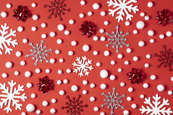 Christmas composition made of white snowflakes and snow on paper red background. New year winter minimal concept. Flat lay — Stock Photo, Image