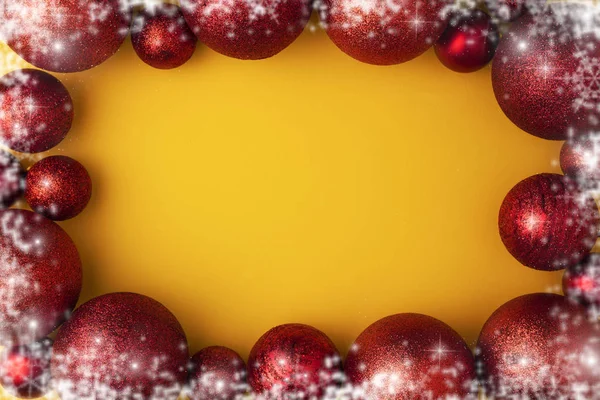 Bordure de cadre en flocon de neige de Noël avec des boules rouges ou des boules de jouets sur fond jaune pastel. Couché plat, vue du dessus — Photo