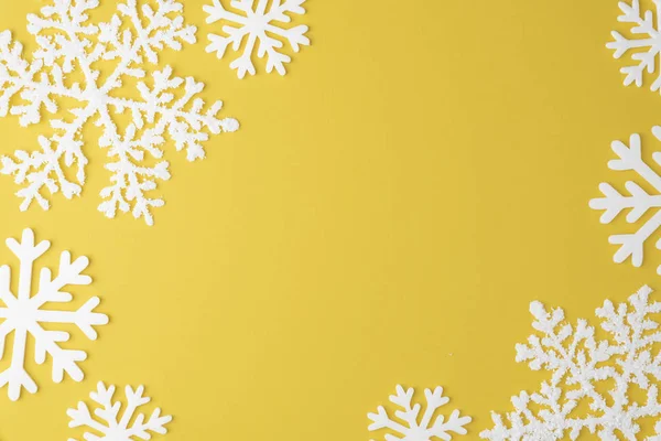 Christmas snowflake mönster med ram kopia utrymme på gul pastell bakgrund. Platt låg. Minimal koncept — Stockfoto