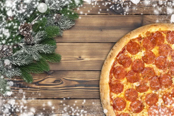 Vánoční feferonkami pizza dekorace vločka na hnědé dřevěné desce — Stock fotografie