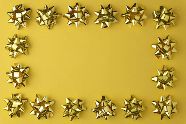 Modèle minimal de Noël avec guirlande d'or brillant sur fond pastel jaune. Couché plat, vue du dessus — Photo