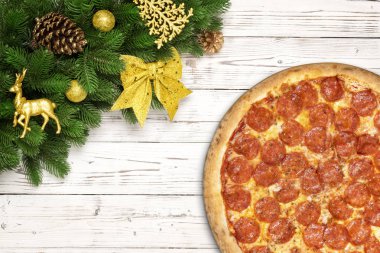 Pizza biberli Noel kar tanesi köknar ile dallar ve yeni yıl oyuncak top, geyik veya Ren geyiği, çam kozalağı, Beyaz ahşap tahta masada yay
