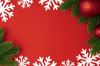 Kırmızı top ve çam dalları ile Noel arka plan kırmızı Kağıt arka plan üzerinde kar tanesi. Kış dekorasyonu