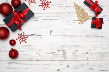 Noel süslemeleri metin yazabileceğiniz boş kopya ile beyaz ahşap zemin üzerinde. Tatil ve kutlama yaratıcı kavramı. Yeni yıl top, altın ağaç hediye kutusu, kar taneleri ile. üstten görünüm